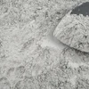 Gray powdery substance spread across surface with mound of dry material