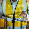 Construction worker analyzing digital data with technology overlay and cranes