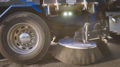Street sweeping vehicle with rotating side brush cleaning surface
