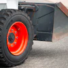 Industrial wheel with orange rim on construction equipment