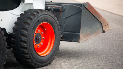 Industrial wheel with orange rim on construction equipment