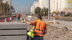 Construction workers in safety vests repairing urban street with road signs