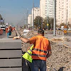 Construction workers in safety vests repairing urban street with road signs