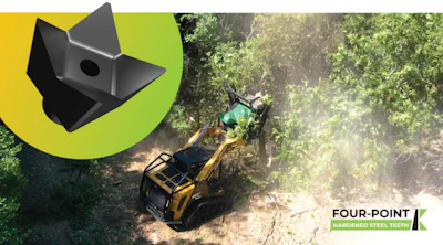 Yellow excavator working in forest clearing with dust and trees in background