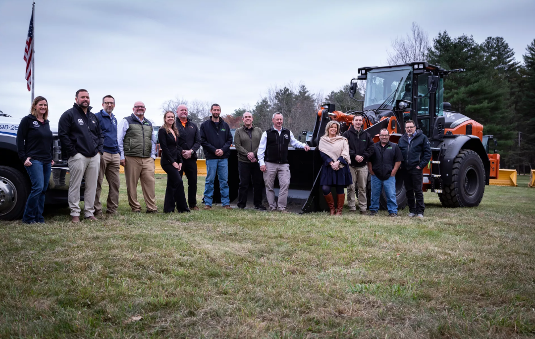 Government or municipal team posing with heavy equipment and American flag
