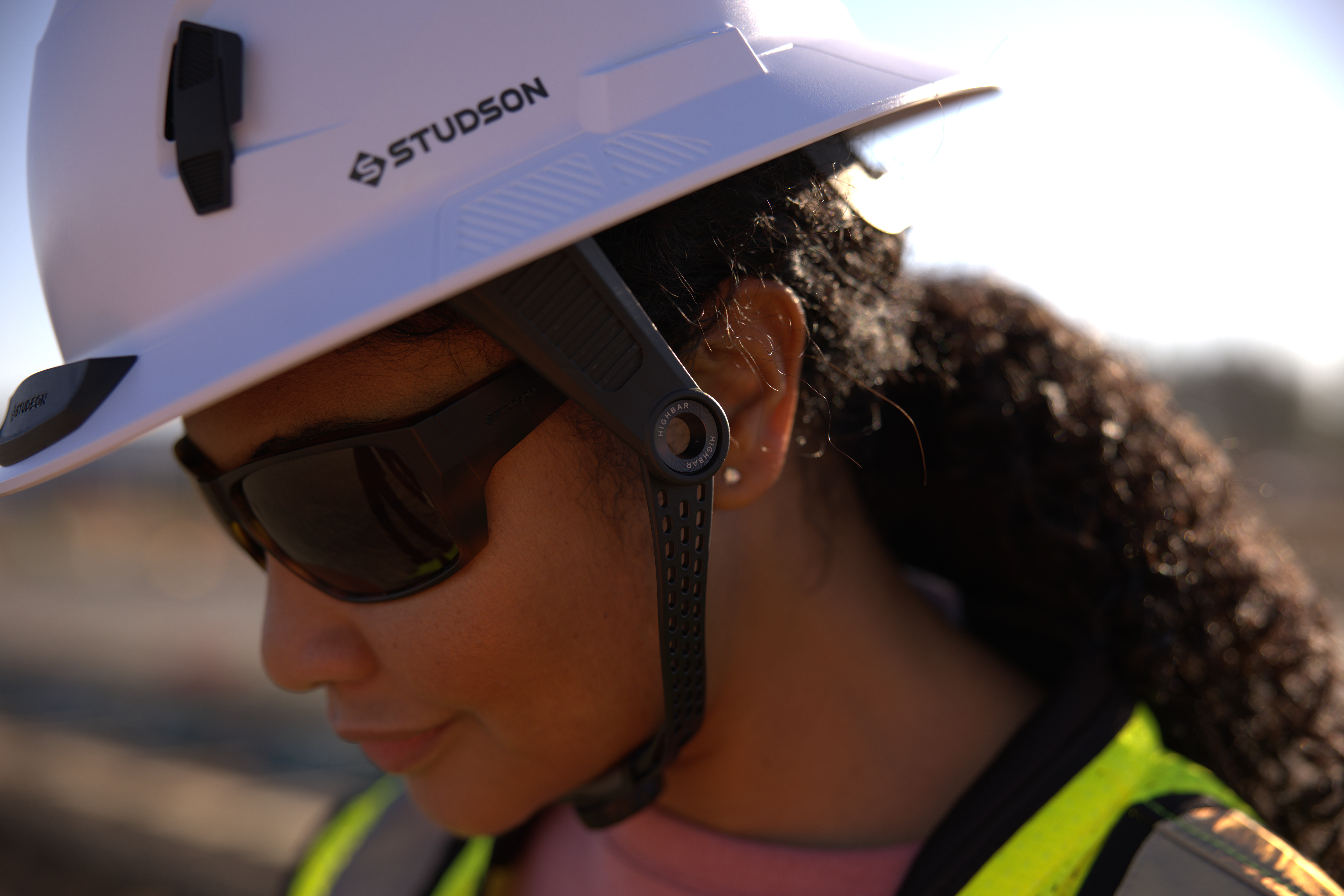 Construction worker wearing white Studson safety helmet and sunglasses