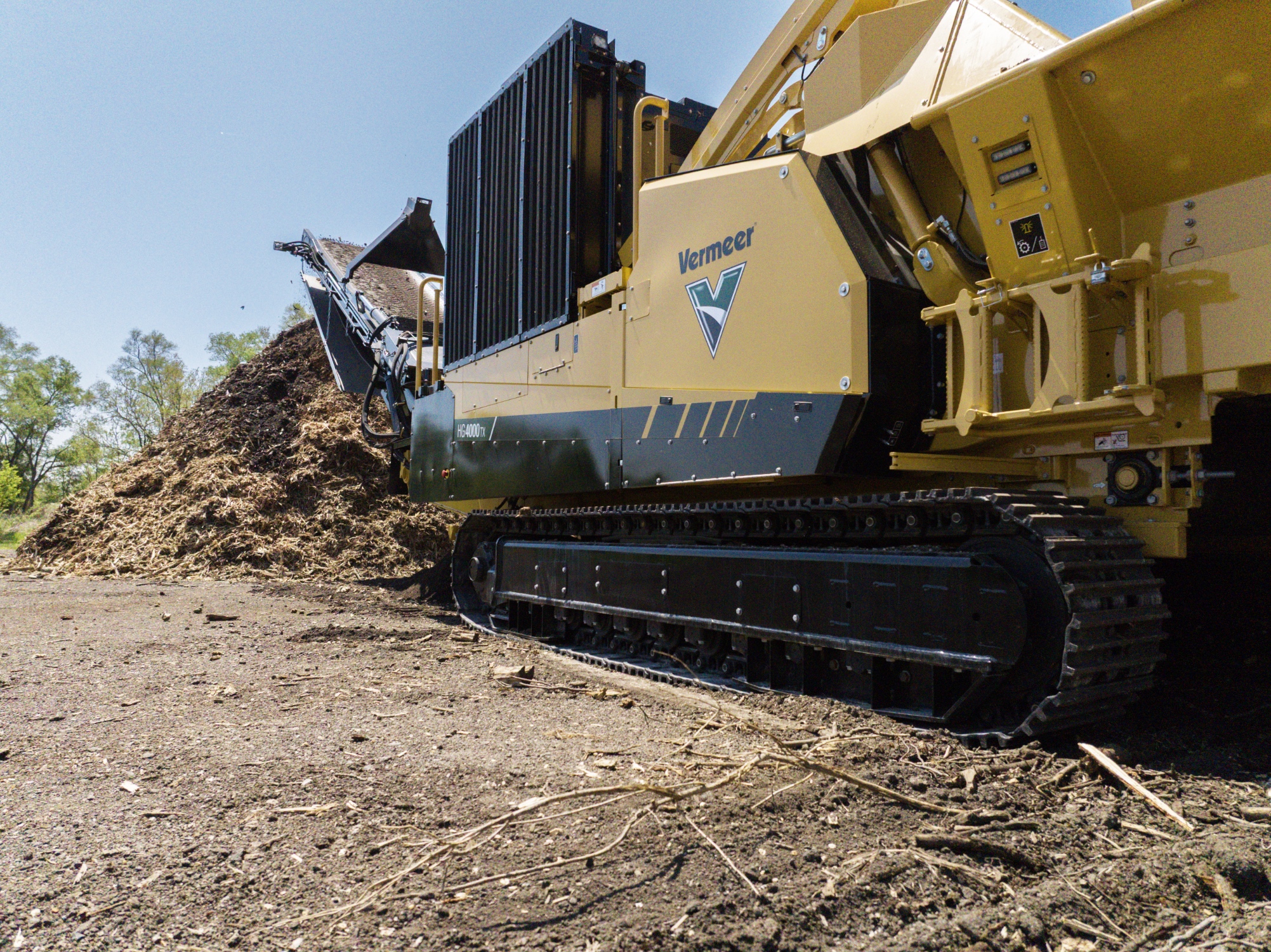 Yellow Vermeer industrial tracked machine processing soil and debris outdoors