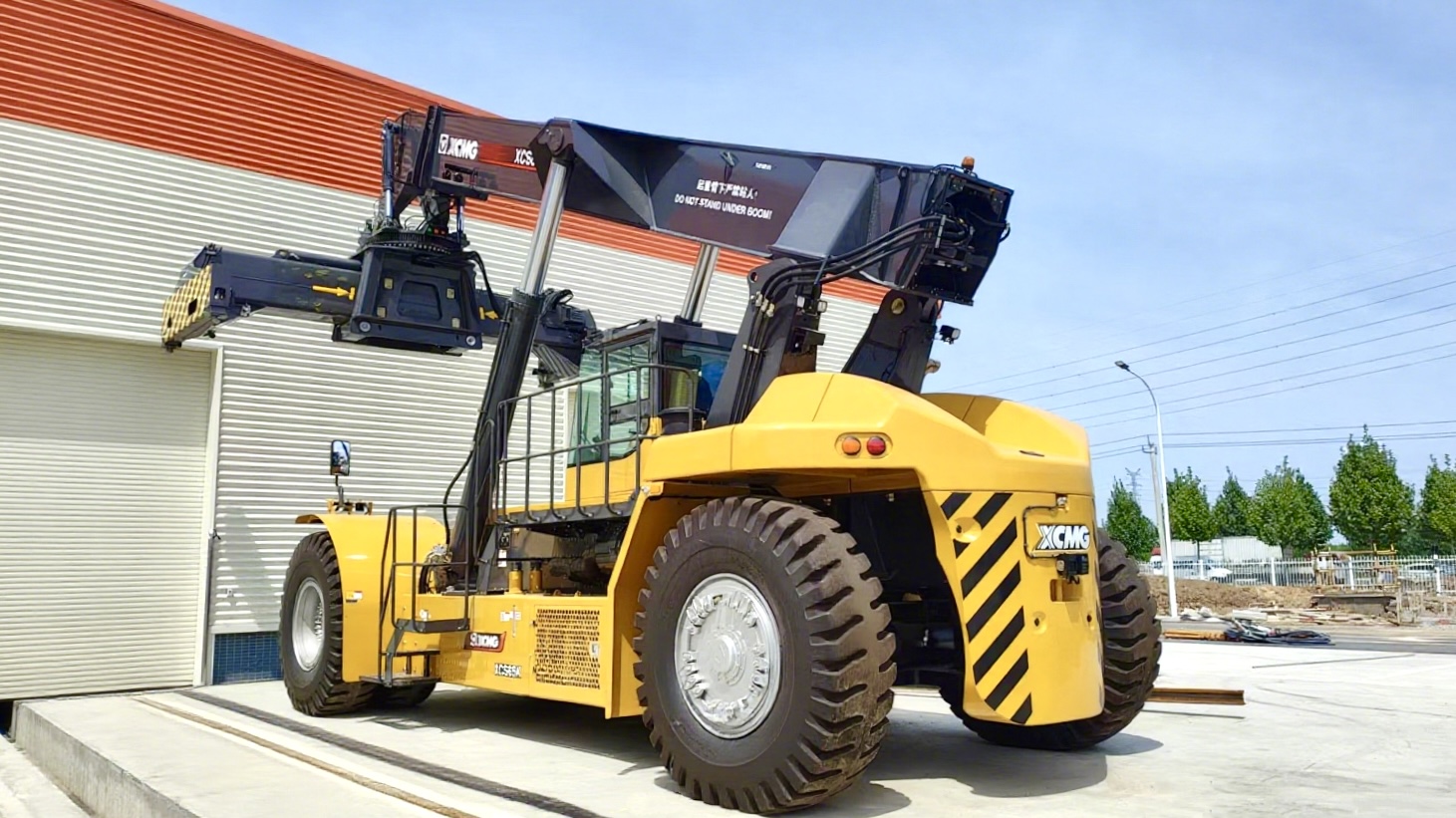 Large yellow XCMG industrial forklift parked near warehouse building