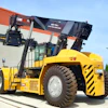 Large yellow XCMG industrial forklift parked near warehouse building