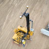 Yellow construction surveying equipment on sandy ground from aerial view