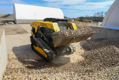 Yellow GEHL skid steer loader moving rocks at construction site