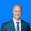 Professional man in blue suit and tie against bright blue background