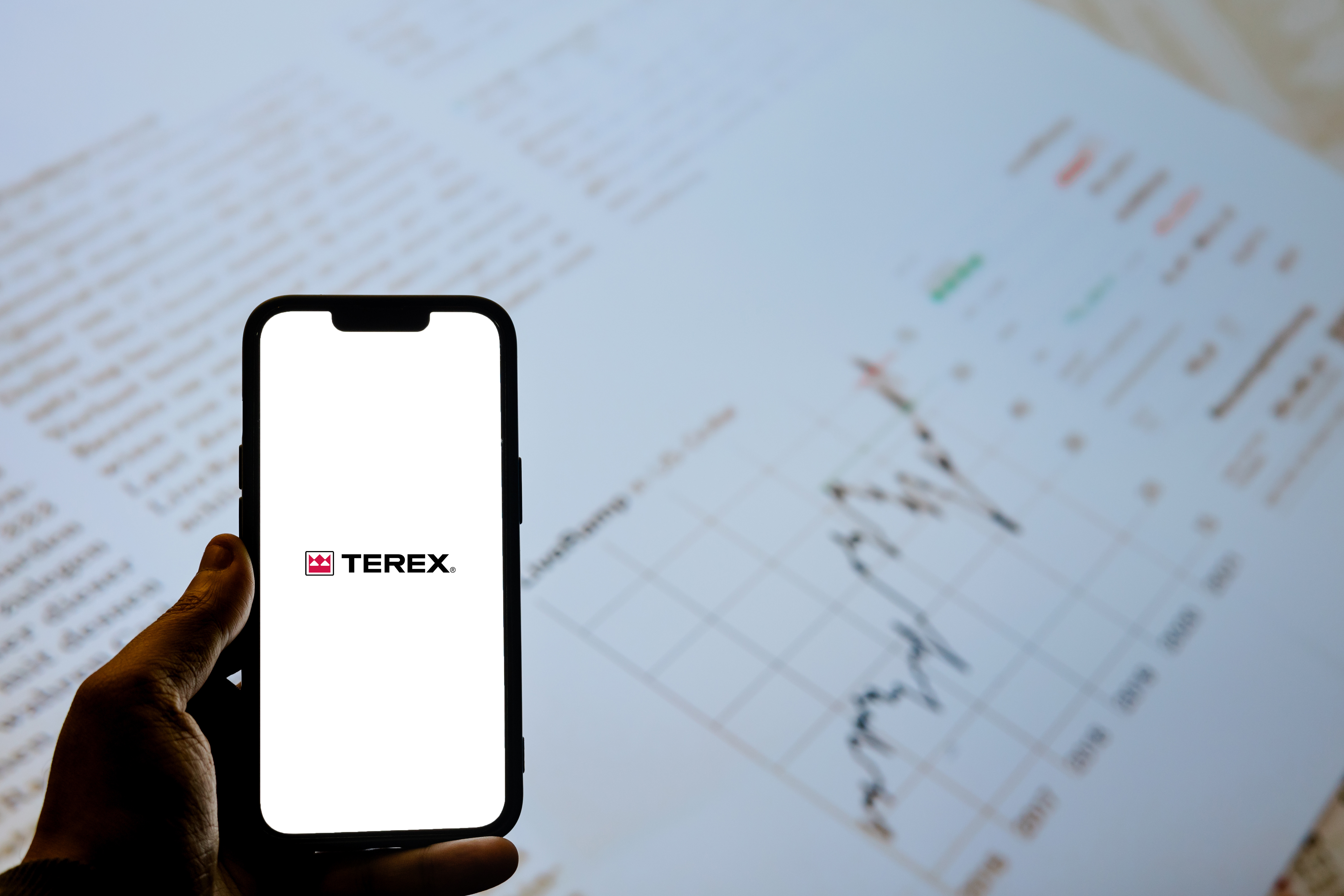Terex corporate logo displayed on smartphone screen over business documents