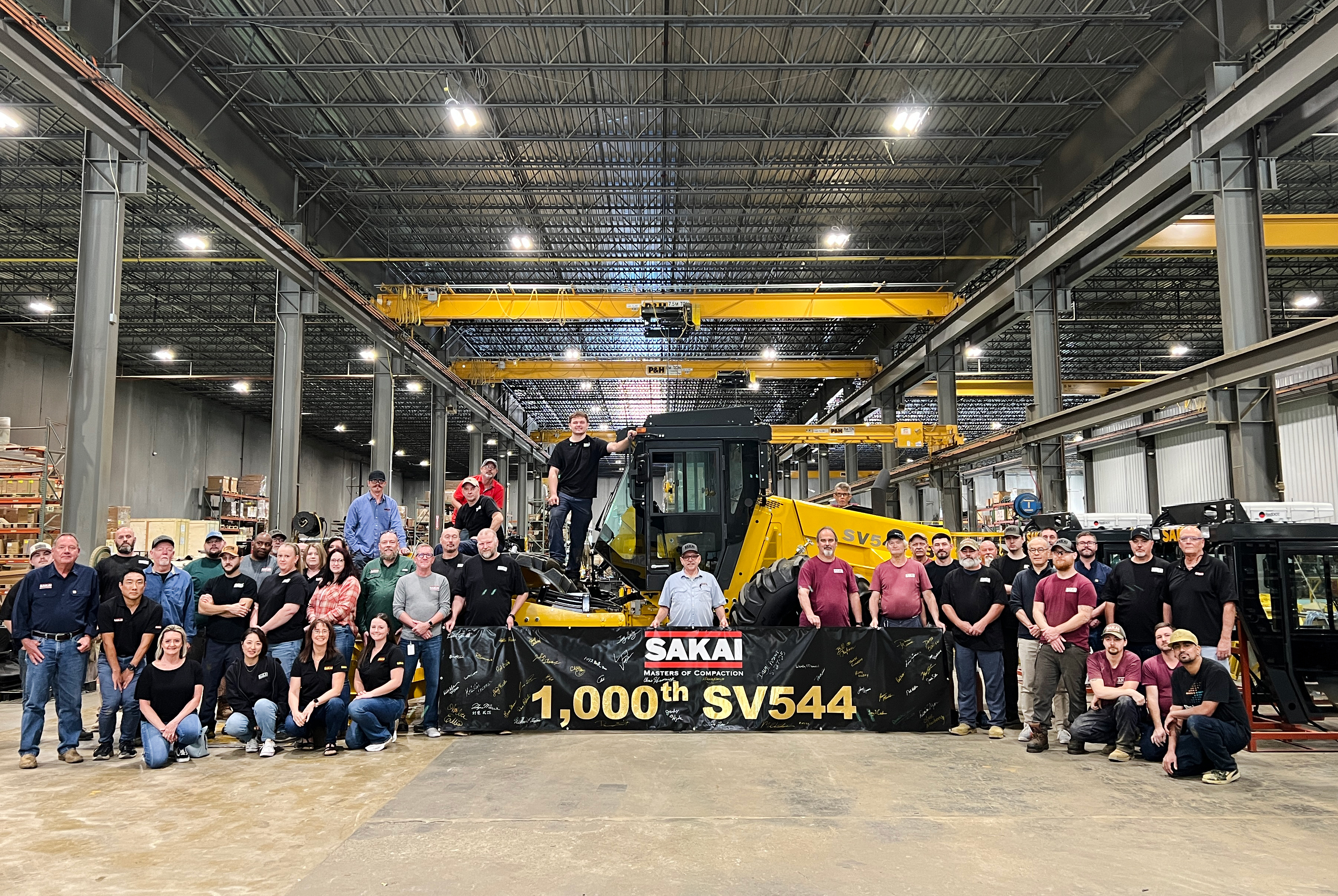 Sakai team celebrates 1,000th SV544 construction machine in industrial warehouse