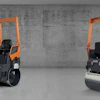 Orange road compactor roller machine in concrete industrial setting