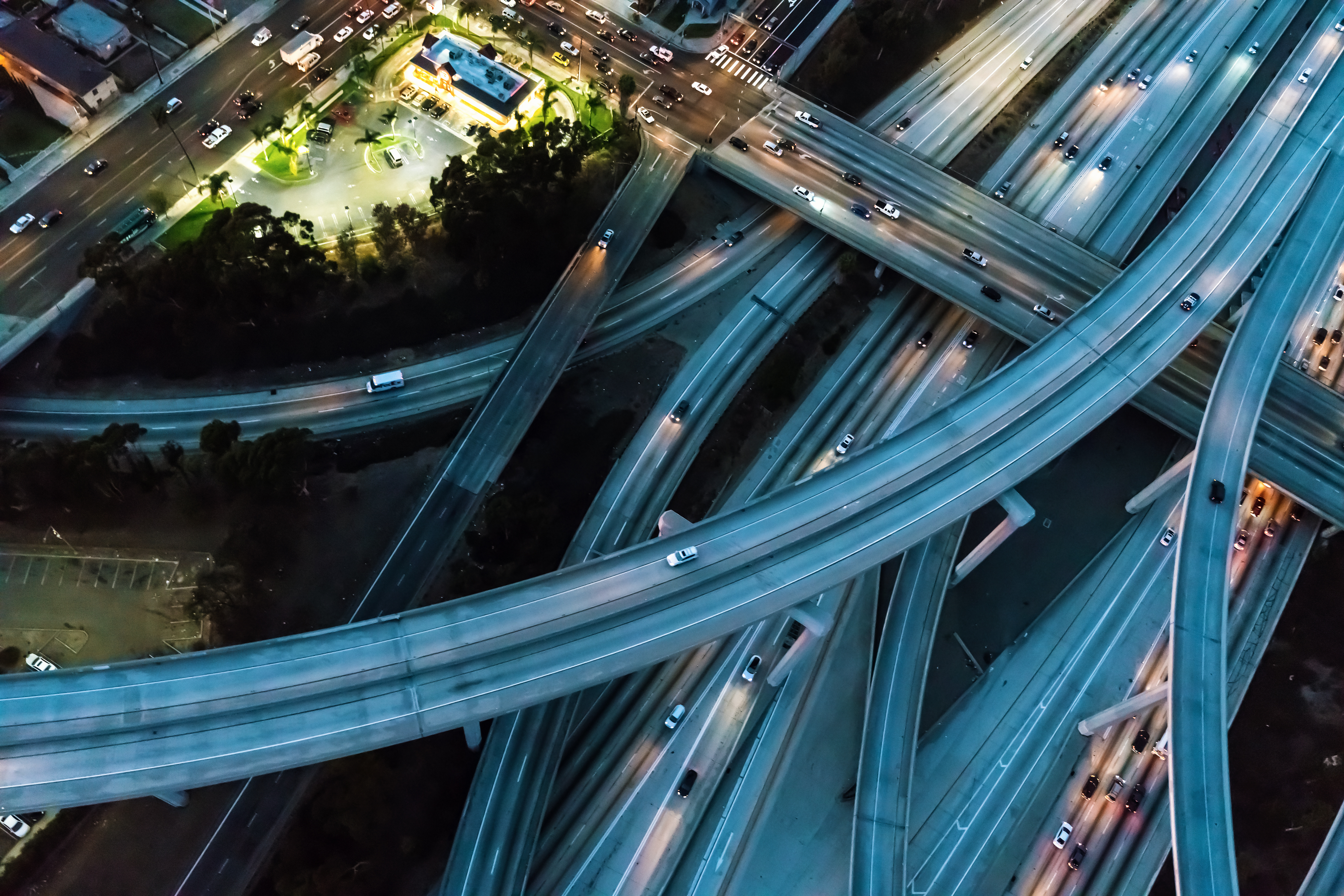 Aerial night view of multi-level highway interchange with illuminated roads and vehicles