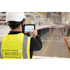 Construction worker in safety vest with Buildots logo using tablet on site