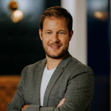 Professional man in gray blazer smiling with confident pose