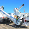 White utility truck with hydraulic crane mounted on industrial work site