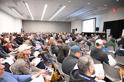 Packed conference room with diverse audience attending professional presentation
