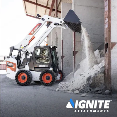 White skid steer loader dumping rocky debris against concrete wall