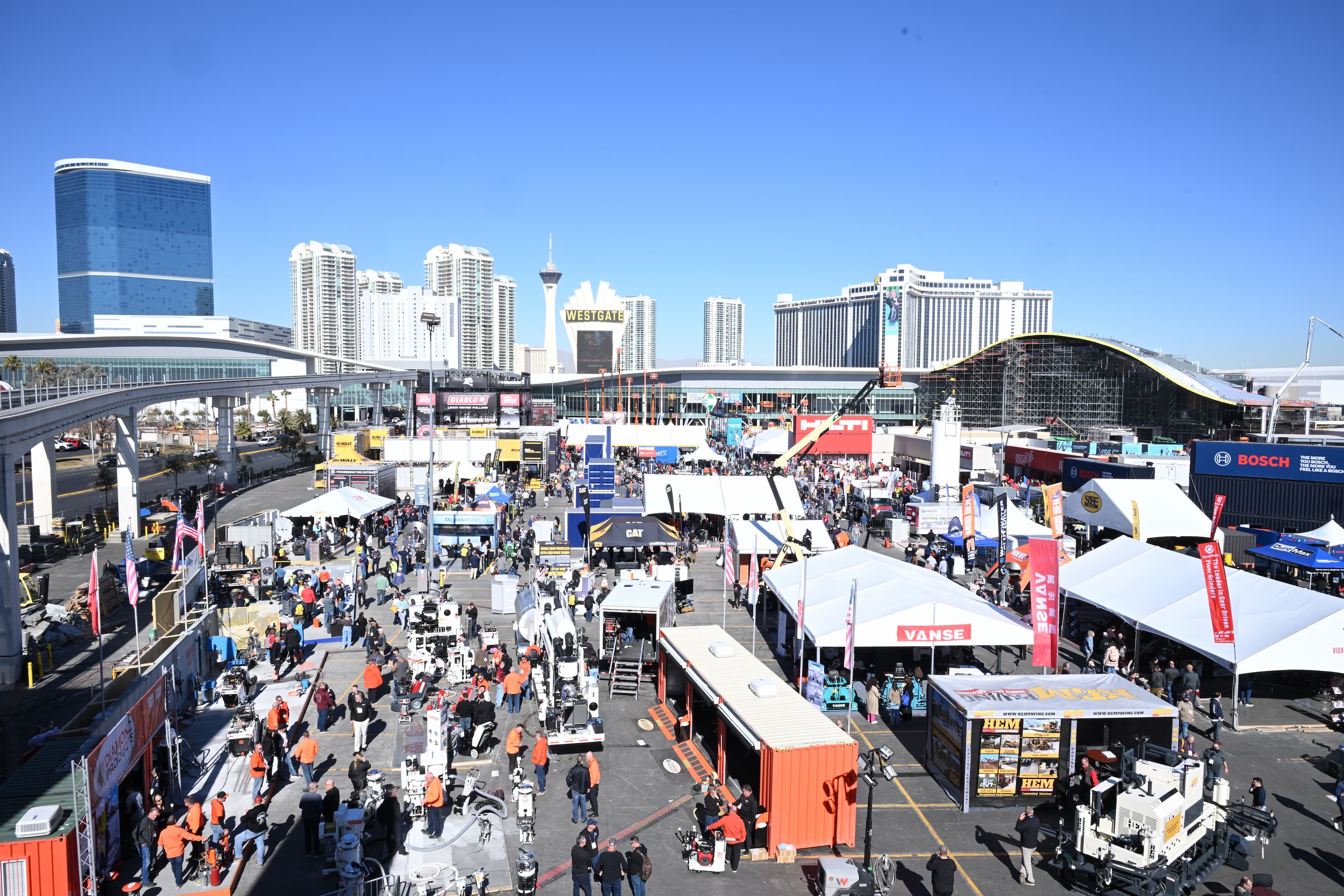 Las Vegas convention center with trade show booths, equipment displays, and city skyline