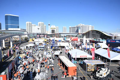 Las Vegas convention center with trade show booths, equipment displays, and city skyline