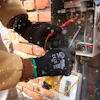 Technician wearing safety gloves repairing electrical panel near brick wall