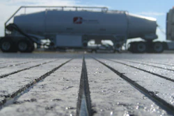 Industrial tanker truck on concrete surface with frost or moisture