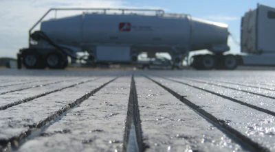 Industrial tanker truck on concrete surface with frost or moisture