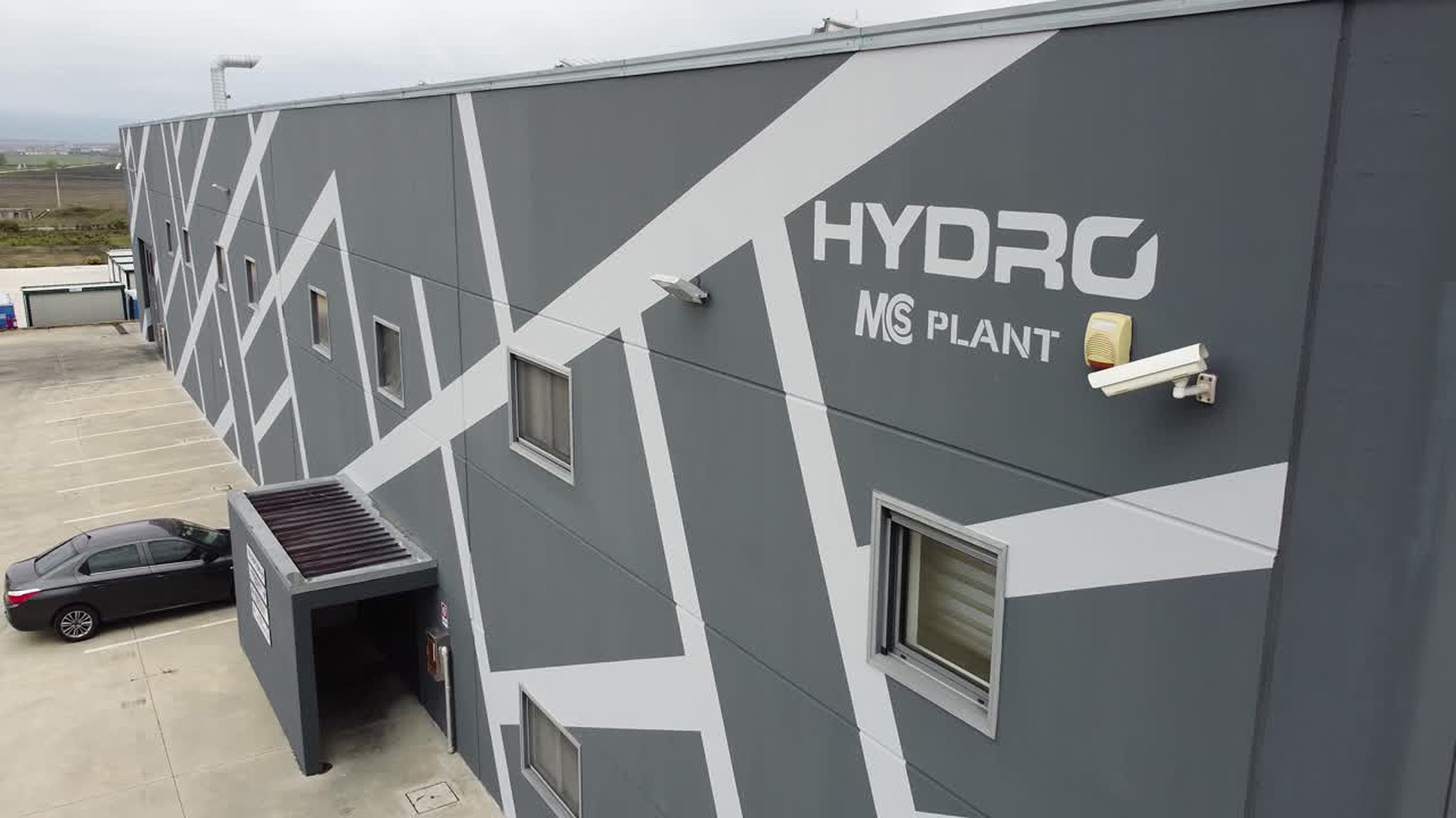 Gray industrial building with Hydro MS Plant logo and security camera