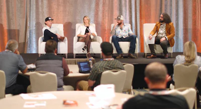 Conference panel with four speakers discussing topics on stage