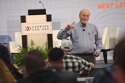 Conexpo Con/Agg conference speaker presenting on stage with event logo