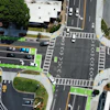 Aerial view of urban intersection with traffic lanes, crosswalks, and green bicycle paths