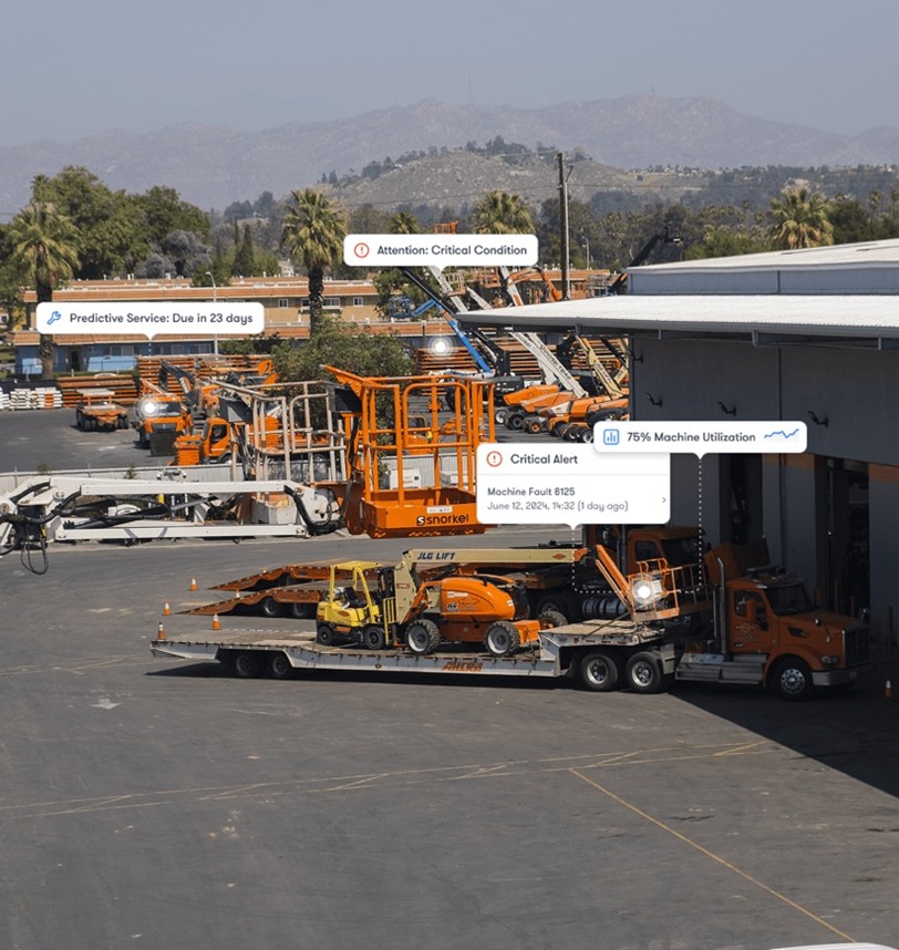 Orange construction equipment and trucks in a yard with mountain landscape background