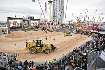 Construction equipment demonstration with yellow CAT wheel loader at industry trade show