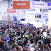 Crowded industrial trade show floor with Komatsu and Bridgestone displays