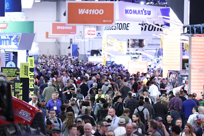 Crowded industrial trade show floor with Komatsu and Bridgestone displays