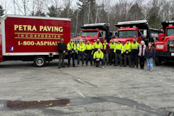 Petra Paving work crew in safety vests standing in front of red trucks and equipment