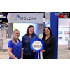 Holcim trade show booth with three professionals and winner ribbon