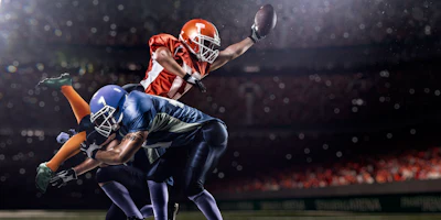 Football players in mid-action, one leaping to catch ball while another defends