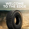 Heavy-duty truck tire displayed against desert landscape with 'Welcome to the Edge' text overlay