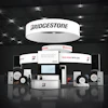 Bridgestone trade show booth with illuminated signage, featuring 'Move More with Less' tagline and multiple product displays
