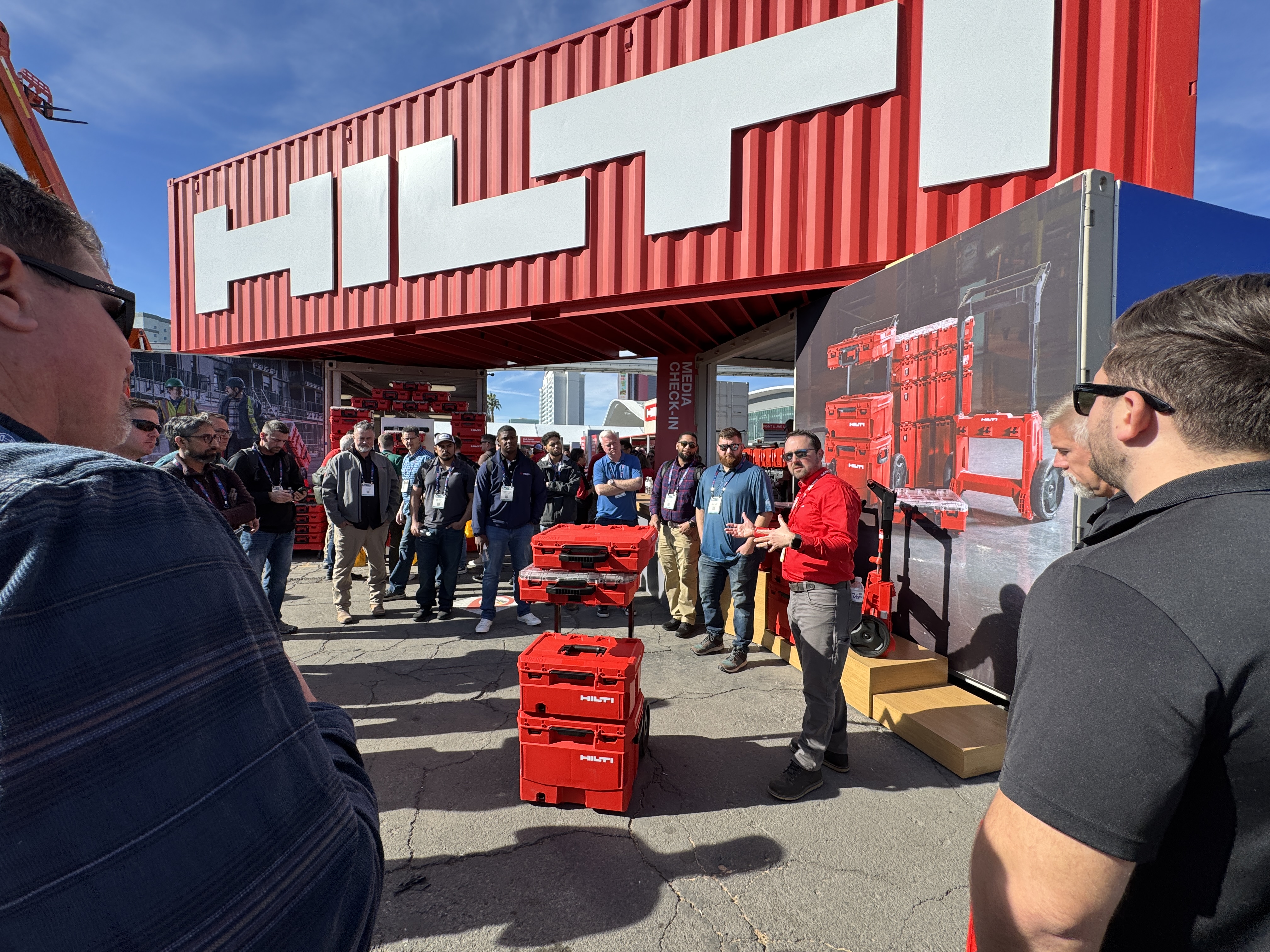 Hilti product demonstration with red tool cases at outdoor trade event