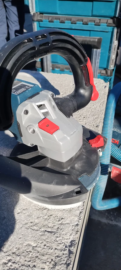 Bosch power tool sander with blue and red details on textured surface