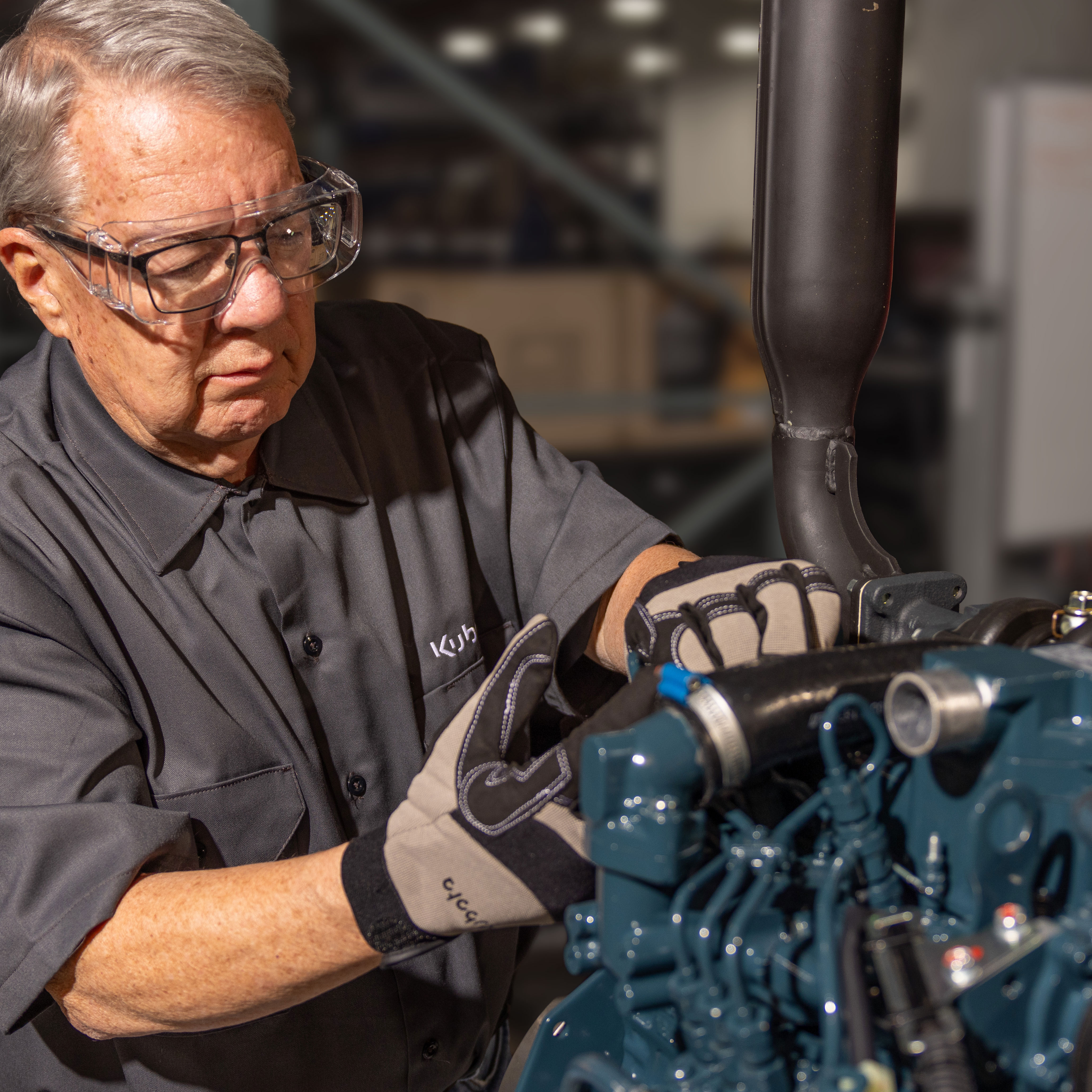 Experienced technician in safety glasses inspecting industrial machinery