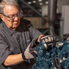 Experienced technician in safety glasses inspecting industrial machinery