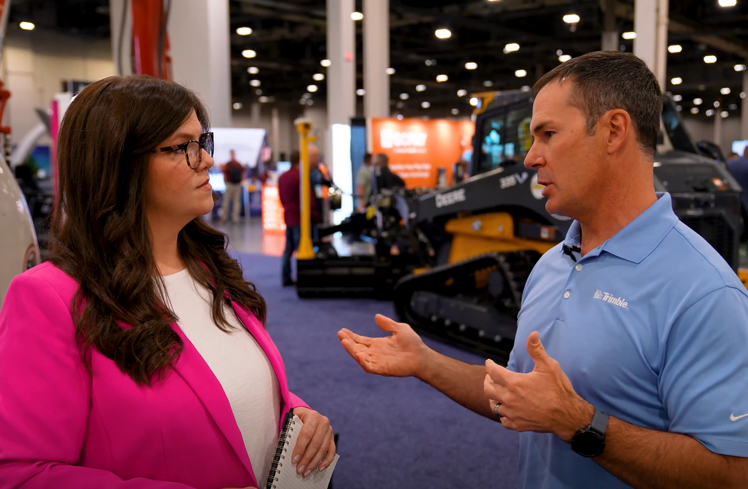 Professional discussing construction equipment at industry trade show