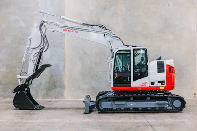 Red and white Takeuchi excavator with black tracks on concrete surface
