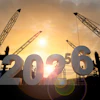 Construction cranes silhouetted against golden sunset with 2026 numbers